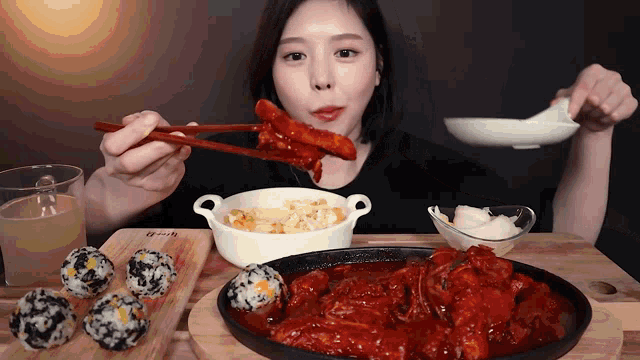 a woman is eating food with chopsticks and a bowl of rice