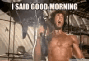 a man without a shirt is holding a gun and shouting .