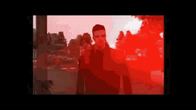 a man in a video game is standing in front of a red background