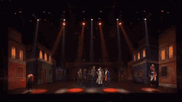 a group of people are standing on a stage in a dark room