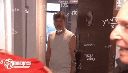 a man is standing in front of a door with mathematical equations on it