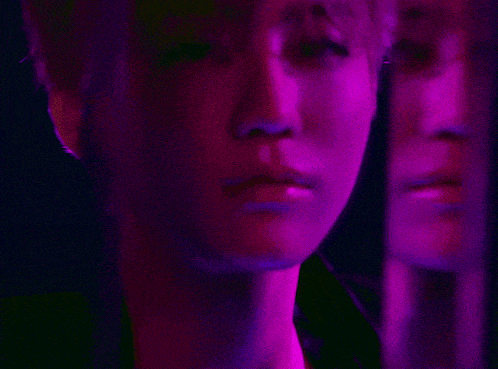 a close up of a person 's face with purple and yellow lights