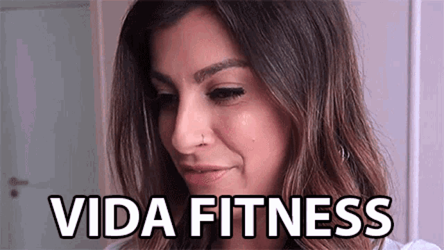 a close up of a woman 's face with the words vida fitness written next to her .