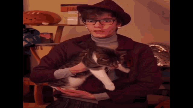 a man in a hat is holding a cat