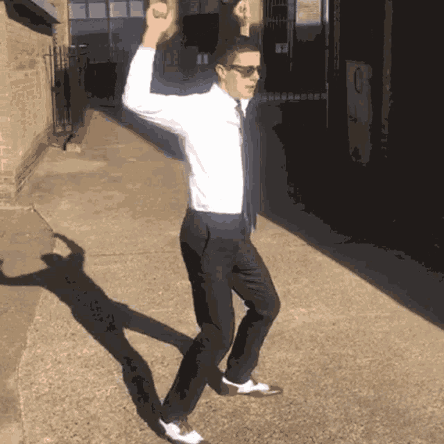 a man in a white shirt and tie is dancing