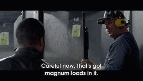a man holding a gun says " careful now that 's got magnum loads in it " while another man looks on