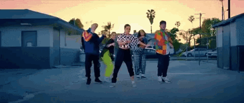 a group of people dancing in a parking lot