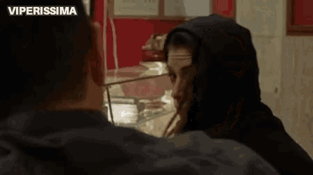 a man and a woman are standing next to each other in a restaurant .
