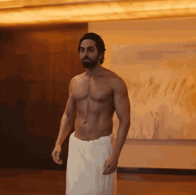 a shirtless man with a beard is wrapped in a towel