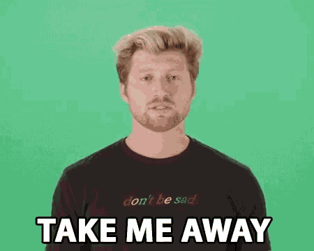 a man with a beard is wearing a black t-shirt that says don 't be sad take me away .