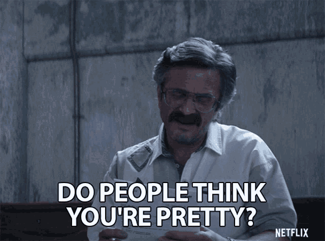 a man with glasses and a mustache says " do people think you 're pretty " while holding a piece of paper