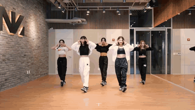 a group of women are dancing in front of a mirror in a dance studio with a sign that says n2 on it