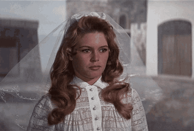 a woman in a white dress with a veil on her hair