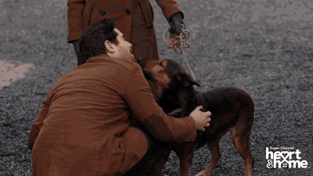 a man kneeling down with a dog in front of a sign that says " heart & home "