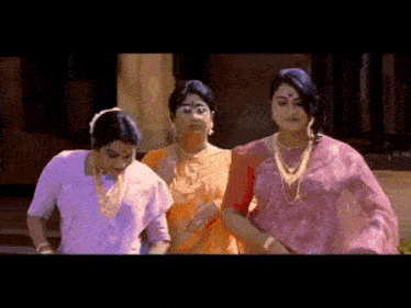 three women are standing next to each other in front of a building