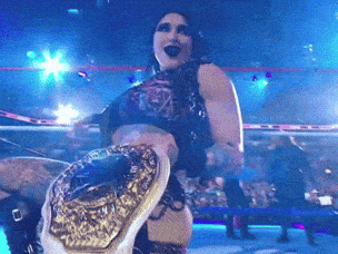 a woman in a wrestling ring with a belt on her waist