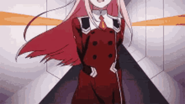 a girl with pink hair and a red suit is standing in a hallway .