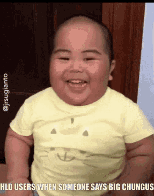 a baby in a yellow shirt with a cat on it