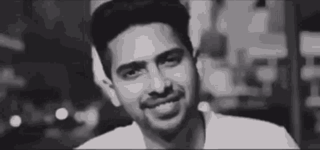 a black and white photo of a smiling man