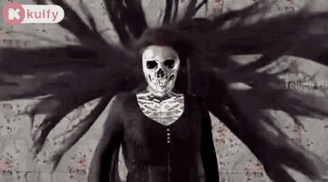 a woman with a skull face painted on her face is standing in front of a wall .