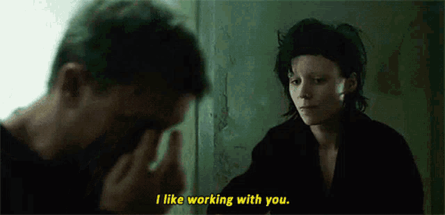 a man and a woman are standing next to each other and the woman says i like working with you .