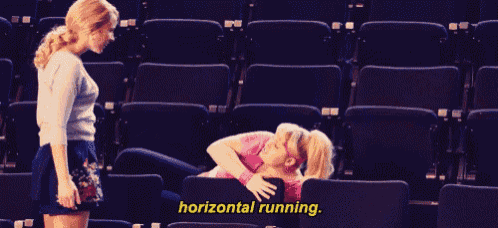 two women are sitting in a stadium and one of them is laying on the floor with the words horizontal running above her