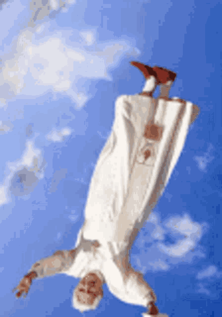 a man in a white robe is flying through the air