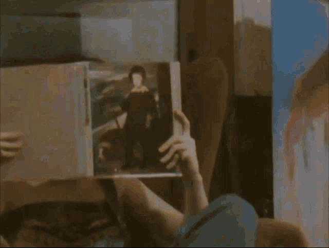 a person is reading a book with a picture of a woman on the cover