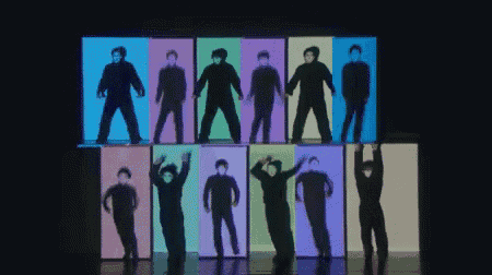 a group of people are standing in front of a wall with colored boxes