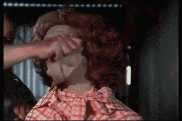 a man in a plaid shirt is touching a woman 's face