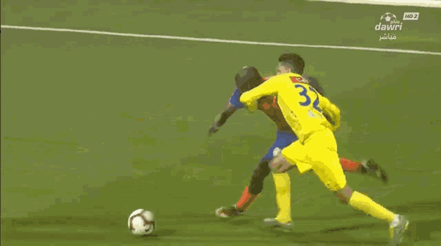 a soccer goalie is diving to catch a ball in front of an advertisement for green goal