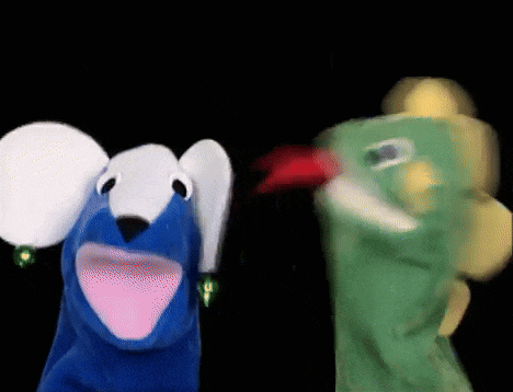 a blue puppet and a green puppet are on a black background