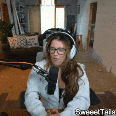 a woman wearing headphones and glasses sits in front of a microphone with sweettails written on the bottom right