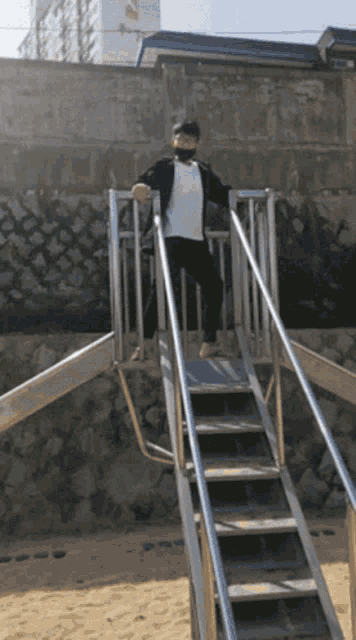 a person wearing a mask is standing on a set of metal stairs