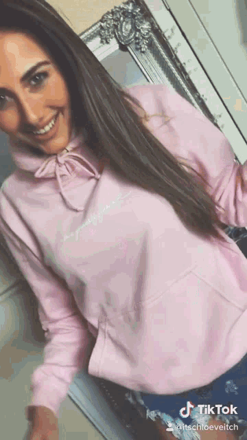 a woman wearing a pink hoodie with a tiktok watermark