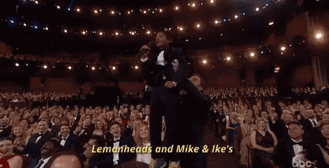 a woman is singing into a microphone in front of a crowd and the words lemonheads and mike & ike 's are visible