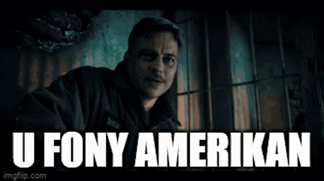 a man is laughing in a dark room with the words " u fony amerikan " behind him