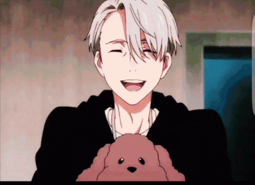a man in a black sweater is holding a stuffed animal and smiling
