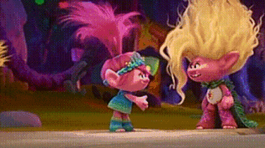 a couple of trolls standing next to each other on a sidewalk in a forest .