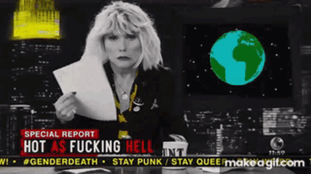 a woman holding a piece of paper in front of a screen that says hot as fucking hell