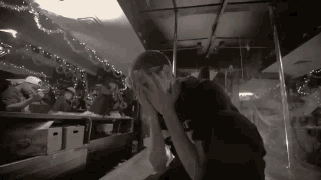 a man covering his face with his hands in a room