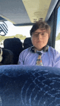 a man wearing a tie and headphones is sitting in a bus