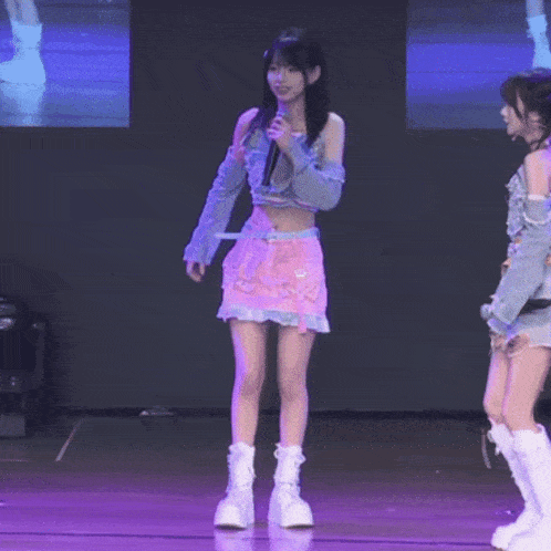 a girl in a pink skirt is holding a microphone