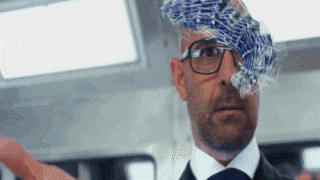 a man in a suit and tie has a stack of cards on his head .