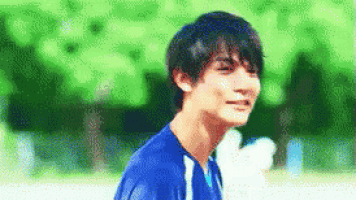 a young man wearing a blue soccer jersey is smiling .