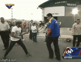 two men are dancing in front of a building that says cojedes on it