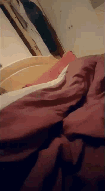 a close up of a bed with a red comforter