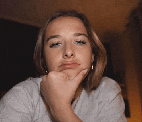 a woman with her hand on her chin making a silly face