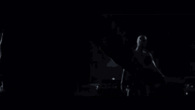 a man in a spiderman costume is crawling on the ground in a dark parking lot .