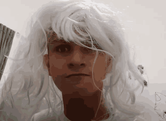 a man is wearing a white wig and making a funny face